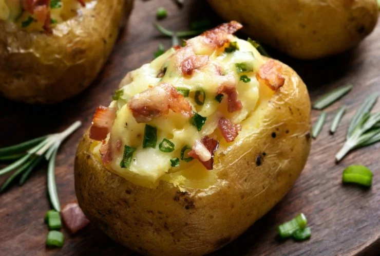 Andremo ad adagiare gli involucri di patate scavati in una teglia da forno foderata e li riempiremo col composto ottenuto. Inumidiremo le patate così farcite con un goccio d’olio e spolvereremo la superficie con altro parmigiano. Cuoceremo in forno a 180 gradi per circa un quarto d’ora fino a dorare per bene: dritti a tavola, sono una bomba di gusto.