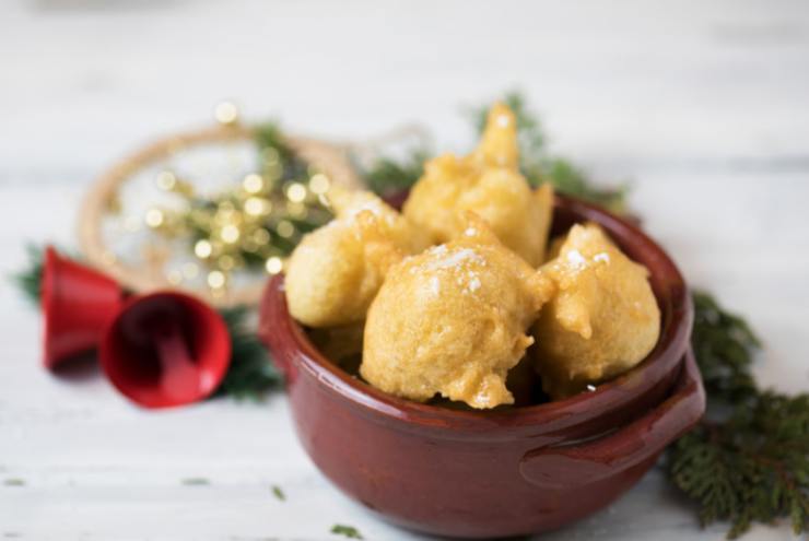 Ripetiamo fino a finire il composto. Sgoccioliamo le pettole in un vassoio con carta assorbente e poi andiamo a rotolarle nello zucchero semolato o nello zucchero a velo: eccole pronte da gustare.