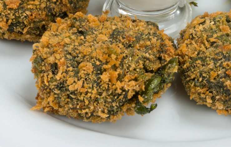 Spolveriamo il composto con una spolverata di parmigiano grattugiato e insaporiamo con sale e pepe. Preleviamo delle porzioni, formiamo delle palline e rotoliamo nel pangrattato. Friggiamo in padella o sistemiamo su di una teglia da forno foderata e cuociamo in forno a 180 gradi per una ventina di minuti.