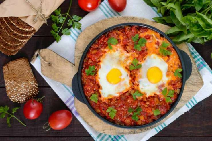 Copriamo di nuovo e facciamo cuocere per altri 5 minuti, fino a quando gli albumi non si saranno rassodati (i tuorli resteranno teneri ma fermi). Controlliamo il sale e insaporiamo con le foglie di basilico fresco, quindi aggiungiamo un pizzico di pepe se di nostro gusto. Serviamo e buon appetito.