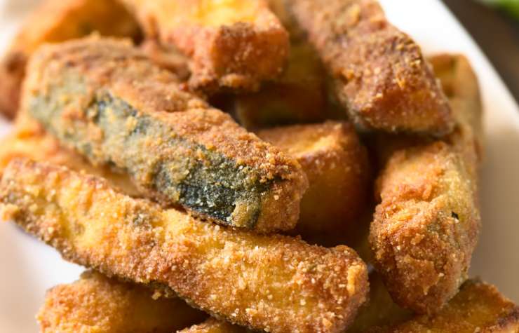 Scaldiamo in una padella l’olio per friggere e una volta caldo immergiamo le nostre zucchine. Lasciamo dorare il tempo necessario, rigirandole quando serve. Una volta cotte sgoccioliamo sulla carta assorbente e andiamo a insaporirle con sale, pepe e aromi a scelta.