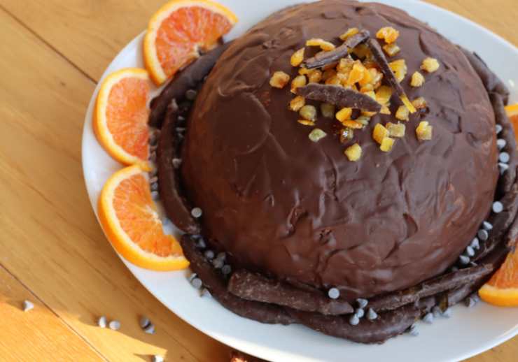 Facciamo intiepidire un paio di minuti. Estraiamo lo zuccotto dall’insalatiera usando la pellicola e capovolgiamo in un vassoio. Ricopriamo con il cioccolato fuso, aiutandoci con un coltello per spalmare su tutto lo zuccotto. Tagliamo a fette e serviamo.