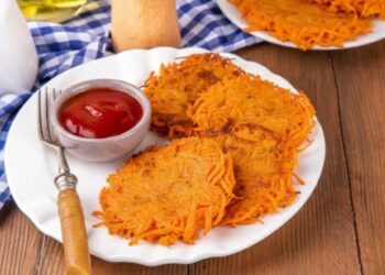 rosti di carote in piatto con ciotola di ketchup