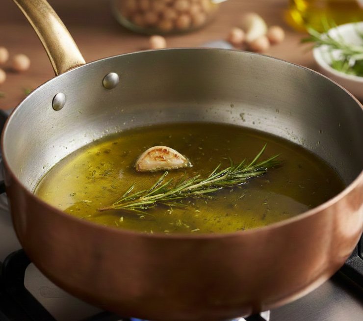 In una pentola capiente, scaldate un giro d’olio extra vergine d’oliva con l’aglio in camicia ed un po’ di rosmarino tritato. Lasciate soffriggere per 2 minuti finché l’olio diventa profumato, poi aggiungete i ceci sgocciolati e coprite con acqua calda o brodo vegetale fino a superare i legumi di due dita.