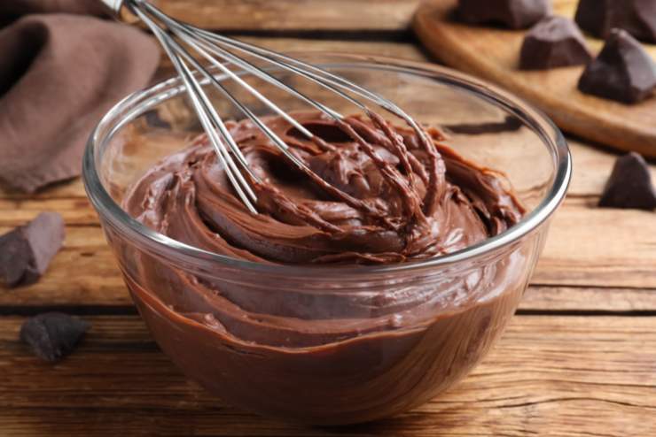 Metteremo in frigo mentre ci occupiamo della crema. In un recipiente lavoriamo il mascarpone con la crema alla nocciola montando con le fruste. Andiamo a riversare la crema ottenuta sulla base di pandoro o savoiardi, livellando;