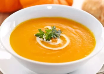 vellutata di zucca cremosa in piatto bianco