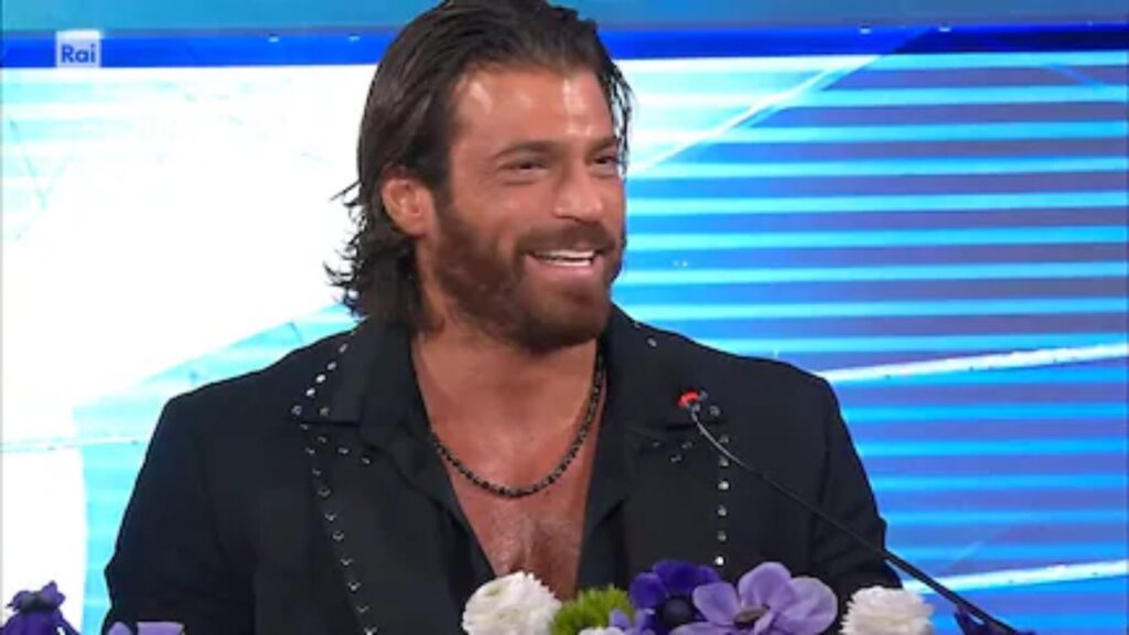can-yaman-sanremo-2026-dieta-ariston Can Yaman sul palco del Festival di Sanremo 2026 in abito elegante scuro mentre sorride al pubblico dell'Ariston, simbolo della sua incredibile forma fisica.