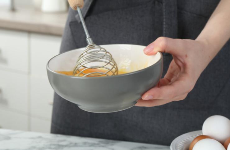 Sbattiamo il tuorlo d’uovo in una ciotolina insieme a un pizzico di sale e di pepe, fino ad ottenere un composto omogeneo. Adagiamo gli hot dog in una teglia da forno foderata e spennelliamo la superficie di ogni rotolino con il composto di uovo ottenuto;