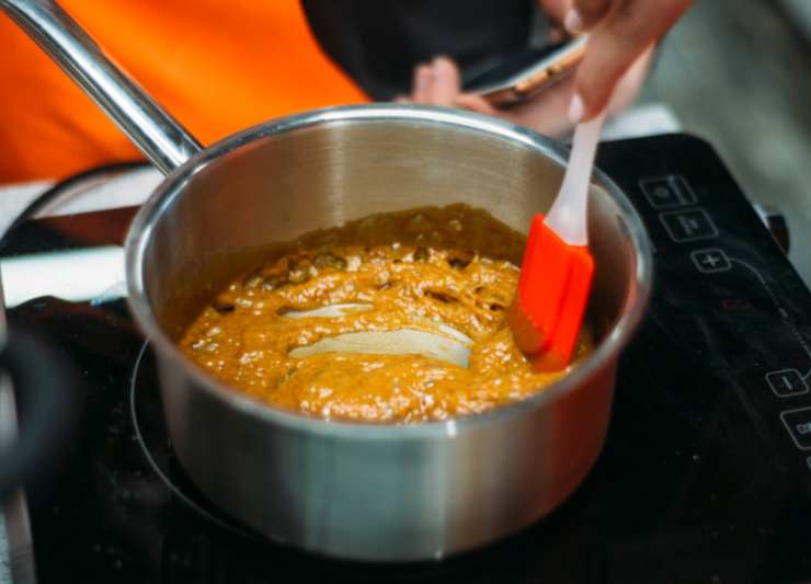 Dedichiamoci intanto al caramello: uniamo il miele e lo zucchero di canna in un tegame e accorpiamo il burro. Portiamo sul fuoco e lasciamo sciogliere a fiamma dolce, quindi mescoliamo per amalgamare il tutto. Quando il composto sfiora il bollore uniamo il bicarbonato e mescoliamo ancora, per poi spegnere la fiamma;