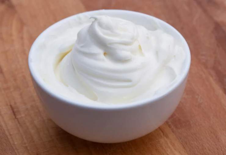 Intanto prepariamo la crema di farcitura: montiamo il formaggio fresco con l’altra parte di burro, lo zucchero a velo e la scorza di limone finché non otterremo una crema liscia;