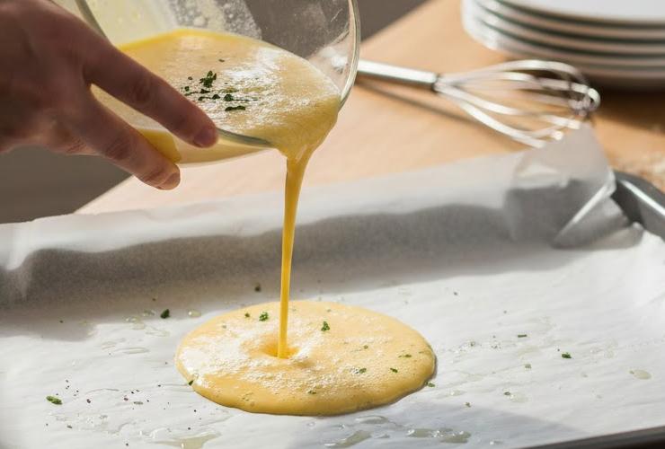 Prendiamo una teglia rettangolare, foderiamo con della carta forno e versiamo il composto di uova nella teglia, cercano di livellare bene;