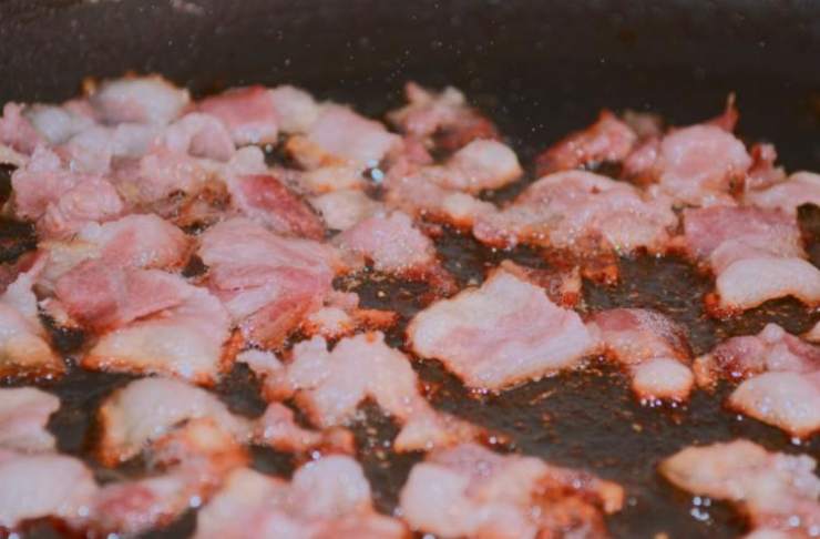 Intanto scaldiamo una padella antiaderente con un filo d’olio d’oliva e un pizzico di aglio in polvere e poi aggiungiamo la pancetta a fiammiferi. Lasciamo rosolare a fuoco medio finché diventa dorata e leggermente croccante, quindi spegniamo la fiamma;
