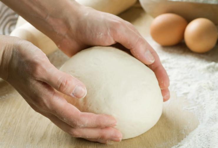 In un secondo recipiente setacciamo l’amido e uniamo lo zucchero, accorpiamo il lievito e poi la scorza di limone e, infine, rompiamo anche le uova. A questo punto uniamo il composto di burro e farina e impastiamo fino ad ottenere un panetto liscio e omogeneo;