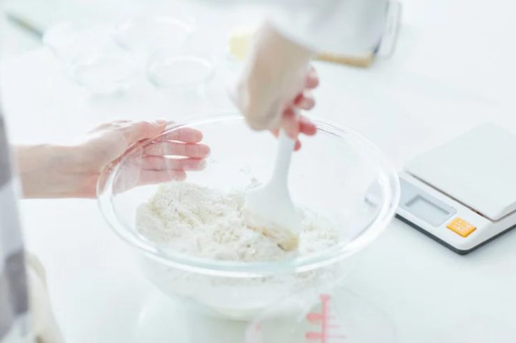 A parte setacciamo la farina con il lievito, uniamo lo zucchero, l’olio di semi e la vanillina. Mescoliamo con una frusta a mano;