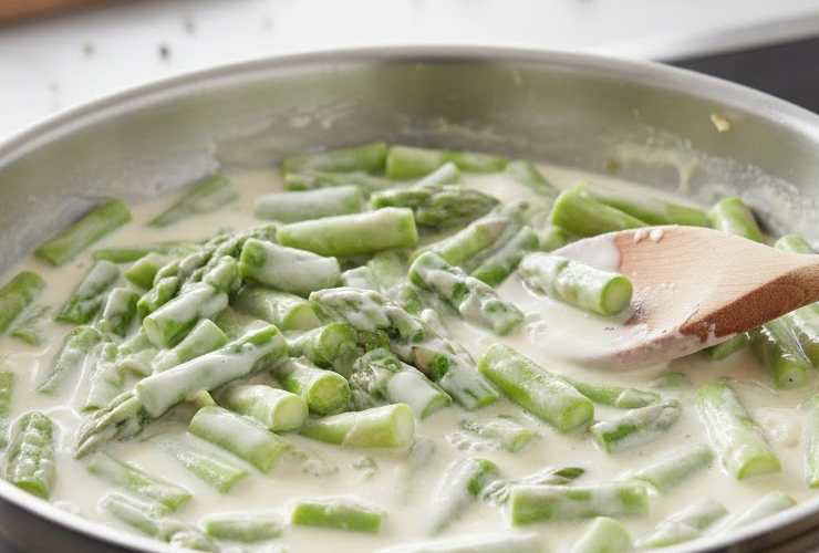 Aggiungiamo i pezzetti di asparagi in padella e saltiamole per qualche minuto; se necessario, usiamo un po’ di acqua di cottura per dare il tempo di cuocersi e intenerirsi. Accorpiamo quindi la panna da cucina in padella, aggiustiamo il sale e amalgamiamo il tutto;