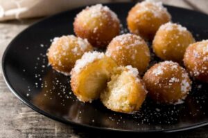 frittelle di arancia in piatto nero