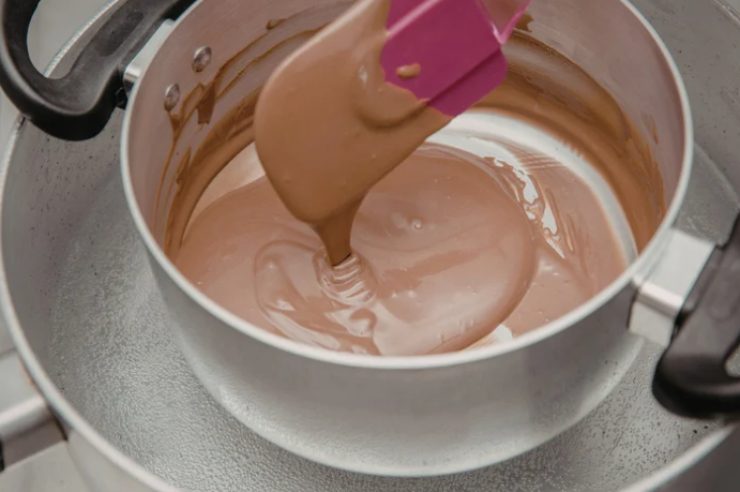 Intanto andiamo a versare il cioccolato scelto e tritato in un tegame e portiamo sul fuoco a bagnomaria fino a sciogliere del tutto e fonderlo completamente;