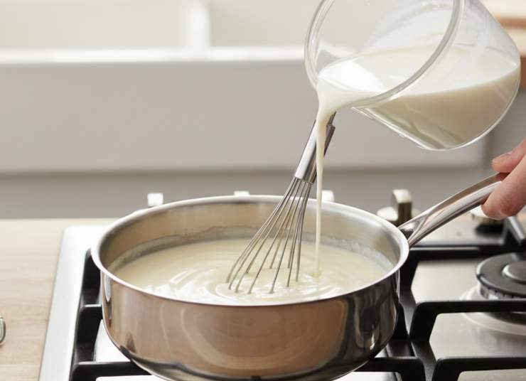 Intanto in un pentolino, fate sciogliere il burro a fuoco dolce. Aggiungete la farina tutta in un colpo e mescolate velocemente: versate il latte a filo, continuando a mescolare con una frusta per evitare grumi. Cuocete finché si addensa, poi profumate con sale e una grattugiata di noce moscata. Tenetela un po’ fluida, servirà a bagnare meglio il pane.