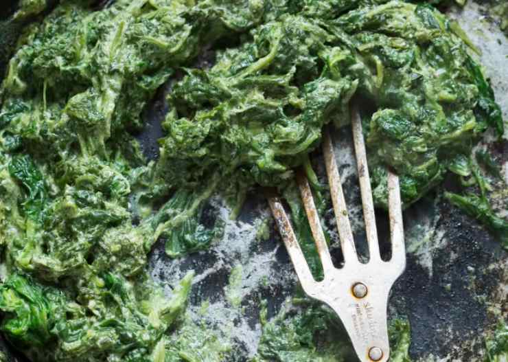 In una padella riversiamo un filo d’olio d’oliva e uniamo il pizzico di aglio in polvere. Lasciamo scaldare e uniamo gli spinaci, quindi lasciamo appassire e soffriggere una decina di minuti. Insaporiamo con sale e pepe, spolveriamo col parmigiano grattugiato e spegniamo la fiamma;