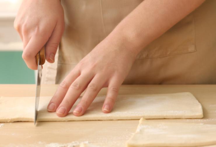 Iniziamo stendendo i nostri rotoli di sfoglia e andando a tagliare 4 triangoli da ognuno: otterremo così 4 cornetti di medie dimensioni da ogni sfoglia;