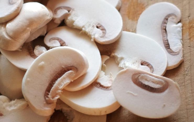 Iniziamo pulendo i funghi champignon: eliminiamo i residui di terra con un panno umido, quindi andiamo a tagliarli a fettine sottili;