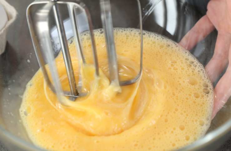Rompiamo le uova in una ciotola aggiungiamo lo zucchero e iniziamo a lavorare con un frullino finché non otteniamo un composto liscio e spumoso;