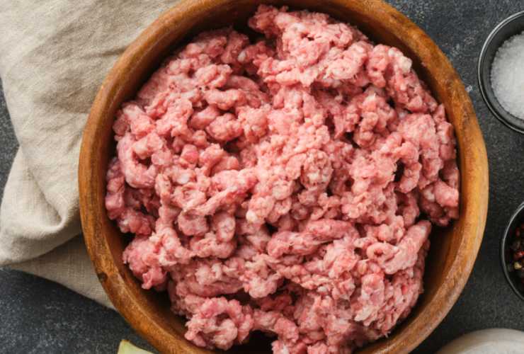 Andiamo quindi a strizzarlo una volta che sarà tenero e riversiamo in un recipiente: aggiungiamo la carne macinata e il parmigiano grattugiato e iniziamo ad amalgamare;