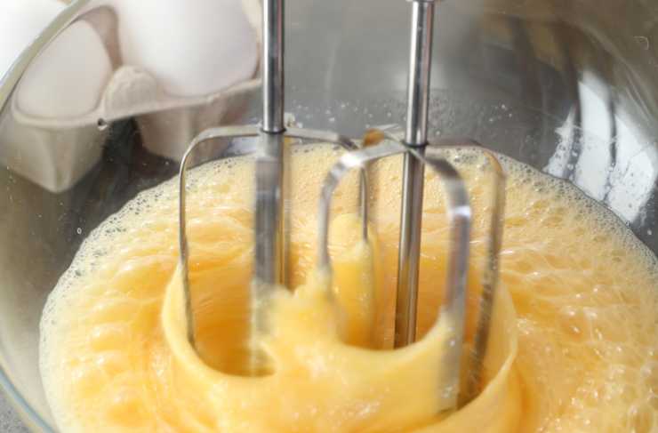 Andiamo a rompere le uova in un recipiente e iniziamo a lavorare con un frullino. Quando iniziano a diventare spumose uniamo lo zucchero poco alla volta, senza mai smettere di sbattere con le fruste: dovremo ottenere un composto molto spumoso;