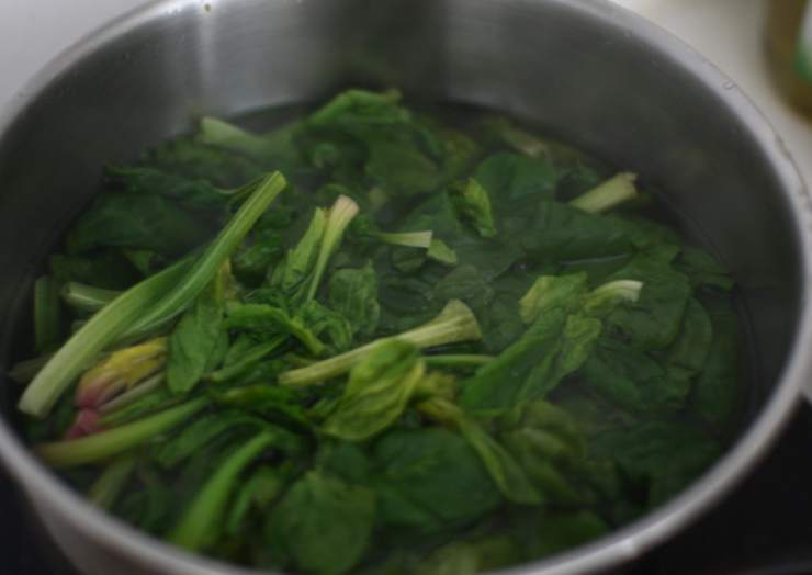 Iniziamo rosolando lo spicchio d’aglio in una padella con un filo d’olio d’oliva e uniamo quindi gli spinaci. Lasciamo rosolare pochi minuti, uniamo un goccio d’acqua e copriamo con un coperchio, facendo cuocere per una decina di minuti. Andiamo poi a insaporire con sale e pepe a nostro gusto e spegniamo la fiamma;