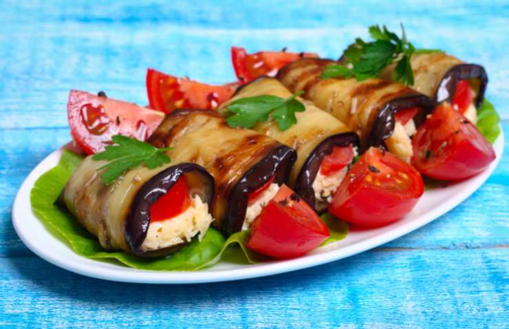 Prendiamo una fetta di melanzana alla volta, spalmiamo sopra un cucchiaio abbondante di ricotta e arrotoliamo con cura, premendo leggermente i bordi per sigillare l’involtino. Ripetiamo per tutte le melanzane fino a finire la ricotta. A questo punto non ci resta che inumidire con un goccio d’olio d’oliva e servire.