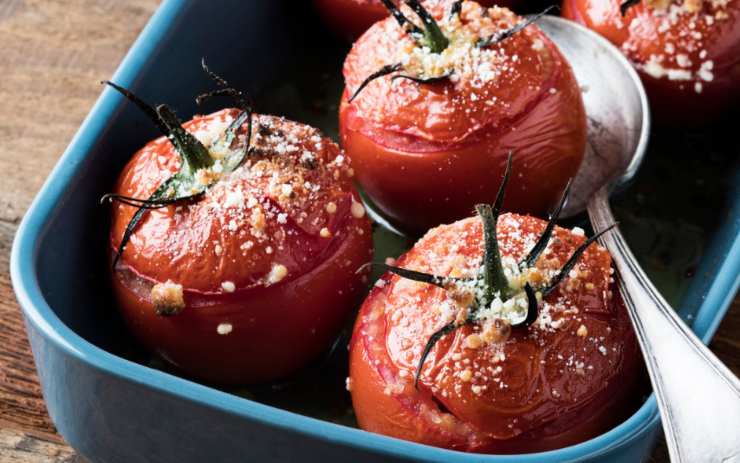 A questo punto usiamo il composto di carne per riempire i pomodori, aiutandoci sempre con un cucchiaino. Adagiamo quindi i pomodori così farciti su di una teglia da forno o in una pirofila (che avremo foderato) e inumidiamo con un goccio d’olio d’oliva. Spolveriamo la superficie con parmigiano e pangrattato e inforniamo per circa 30 minuti.