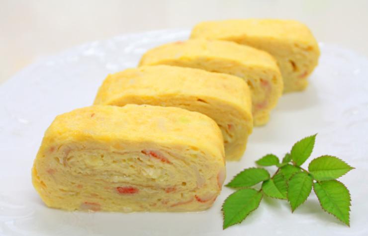 Distribuiamo le fette di prosciutto cotto su tutta la superficie, lasciando un pochino di spazio ai bordi. Facciamo lo stesso col formaggio dolce scelto. Arrotoliamo la frittata partendo dal lato più corto, aiutandoci con la carta. Chiudiamo il rotolo a caramella avvolgendo nella carta da forno e lo lasciamo riposare per almeno dieci minuti. Eliminiamo quindi la carta e tagliamo a fette.