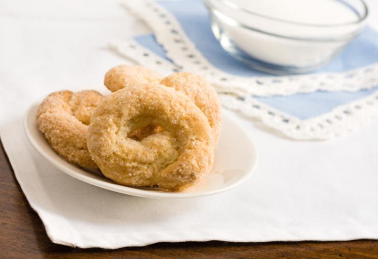 Lasciamo riposare il panetto mezz’ora in frigo avvolto nella pellicola, poi riprendiamolo e ricaviamo dei pezzi più piccoli. Lavoriamo a formare salsicciotti sottili che chiuderemo alle estremità. Adagiamo i taralli sulla carta da forno e cuociamo a 180 gradi per 15/20 minuti finché non saranno ben dorati. Lasciamo raffreddare prima di gustare.