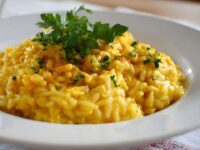 Un piatto di riso bianco fumante su un tavolo da cucina con un segnale di pericolo biologico rosso in primo piano