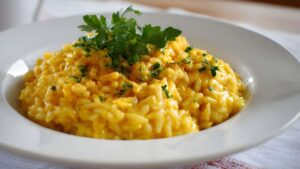 sindrome-riso-fritto-pericolo-cereulide Un piatto di riso bianco fumante su un tavolo da cucina con un segnale di pericolo biologico rosso in primo piano