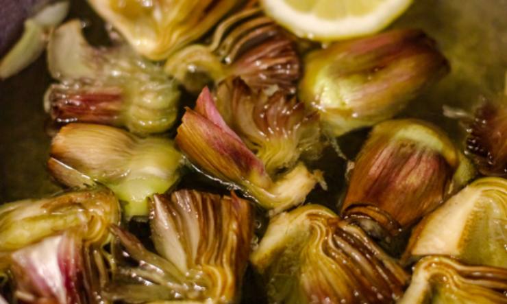 Scoliamo i carciofi e spostiamoli in una pentola con acqua salata: sbollentiamo sul fuoco per una decina di minuti, il tempo di ammorbidirli senza però lessarli;