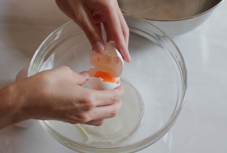 In una ciotola capiente, intanto, andiamo a rompere le uova e uniamo lo zucchero, quindi lavoriamo con una frusta a mano o un frullino fino a ottenere un composto chiaro e abbastanza liscio;