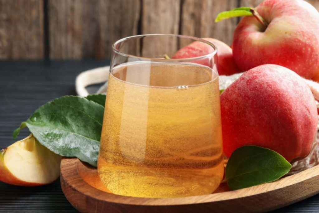 succo di mela in bicchiere su tagliere