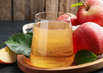 succo di mela in bicchiere su tagliere