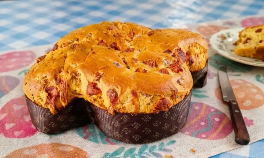 una colomba rustica salata ripiena di salumi e formaggi su tovaglia pasquale