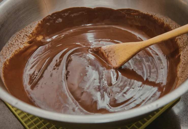 Iniziamo a mescolare con una spatola o un cucchiaio di legno, assicurandoci di raschiare bene il fondo e i bordi, tenendo sempre la fiamma molto bassa. Proseguiamo la cottura per circa 10-15 minuti, finché il composto non inizia ad addensare: quando sarà abbastanza “sodo” da staccarsi dal fondo spegniamo la fiamma;