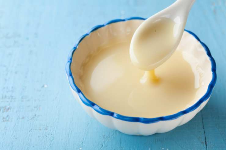 In un pentolino versiamo il latte condensato insieme ai 20 grammi di burro. Tritiamo quindi il cioccolato fondente e uniamo al latte e al burro, portando sul fuoco a fiamma dolce;