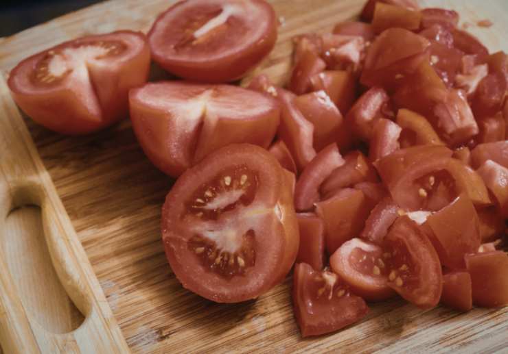 Condiamo i pomodori con olio d’oliva, sale, pepe e aromi a nostro gusto. Tagliamo a pezzetti anche il parmigiano e teniamone una porzione grattugiata da parte. Scoliamo la pasta una volta cotta e dopo averla scolata riversiamola in un’insalatiera;