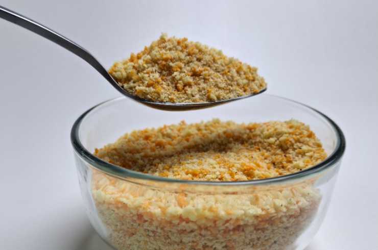 Mescoliamo e uniamo al composto il parmigiano grattugiato, gli aromi scelti e il sale e il pepe a nostro gusto. Lavoriamo ancora e andiamo a spolverare il pangrattato: regoliamoci a occhio per ottenere un composto appiccicoso, non troppo liquido;