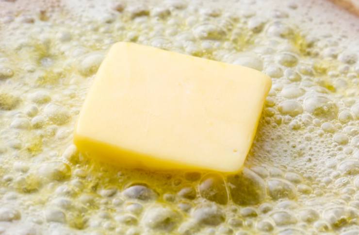 Sciogliamo il burro a bagnomaria e accorpiamo alle uova, mescolando per amalgamare, poi, poco alla volta, uniamo anche gli ingredienti secchi, mescolando sempre con una frusta a mano e senza montare troppo;