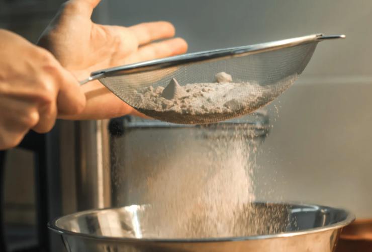 Accorpiamo la vanillina e poi passiamo ad aggiungere le polveri setacciate: la farina e il lievito. Inglobiamo con le fruste e spolveriamo le noci tritate all’interno della crema ottenuta. A questo punto uniamo anche le gocce di cioccolato e distribuiamo con una spatola;