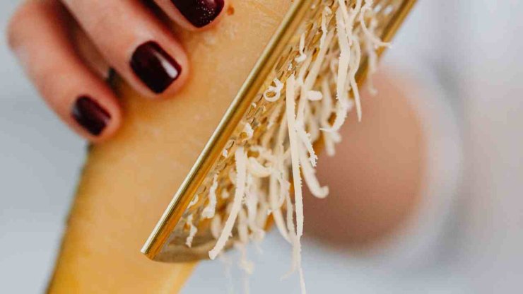 Iniziate prendendo le patate, lavatele e pelatele quindi grattugiatele grossolanamente. Ecco il primo segreto: fatto ciò, strizzatele con un canovaccio pulito per eliminare l’eccesso di amido ed acqua. Grattugiate il Montasio mescolando metà mezzano e metà stagionato: quello fresco rilascia troppo siero, quello stagionato crea la struttura.