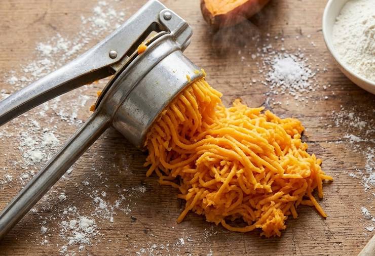 Fate cadere la polpa su un piano di lavoro pulito, allargandola per far evaporare l’umidità residua: non iniziate a impastare finché la polpa è bollente o la farina si trasformerà in colla. Aspettate quindi che sia ben tiepida al tatto e solo in quel momento aggiungete gli ingredienti asciutti: sale, la noce moscata, la fecola e circa metà della farina.