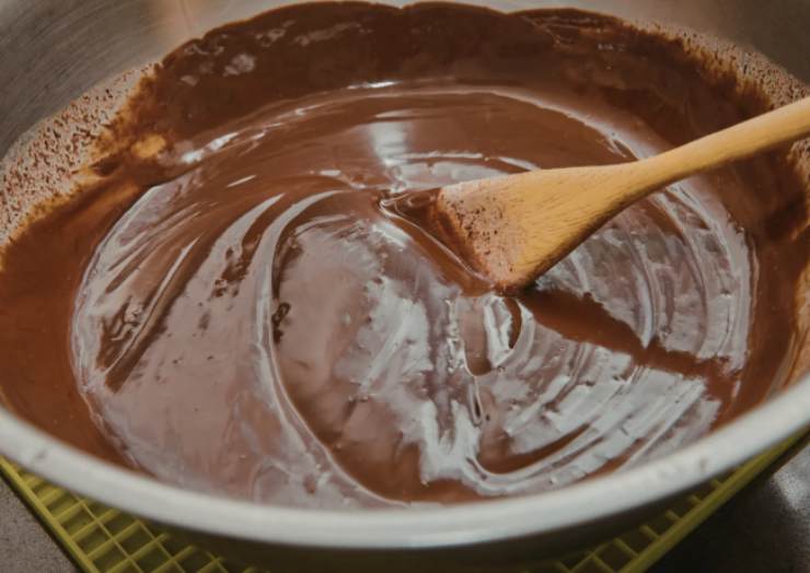 Iniziamo sminuzzando i due cioccolati in due tegami diversi e portiamo entrambi sul fuoco a bagnomaria facendo sciogliere del tutto. Intanto foderiamo uno stampo da plumcake (o simile) con della carta da forno, avendo cura di far aderire bene al fondo e ai bordi;
