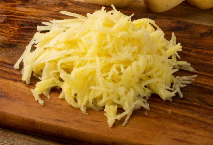 Laviamo le patate, sbucciamole e poi grattugiamole finemente. Strizziamole con delicatezza per eliminare l’acqua in eccesso e riversiamo in una ciotola per insaporirle con sale, pepe e aromi a nostro gusto;